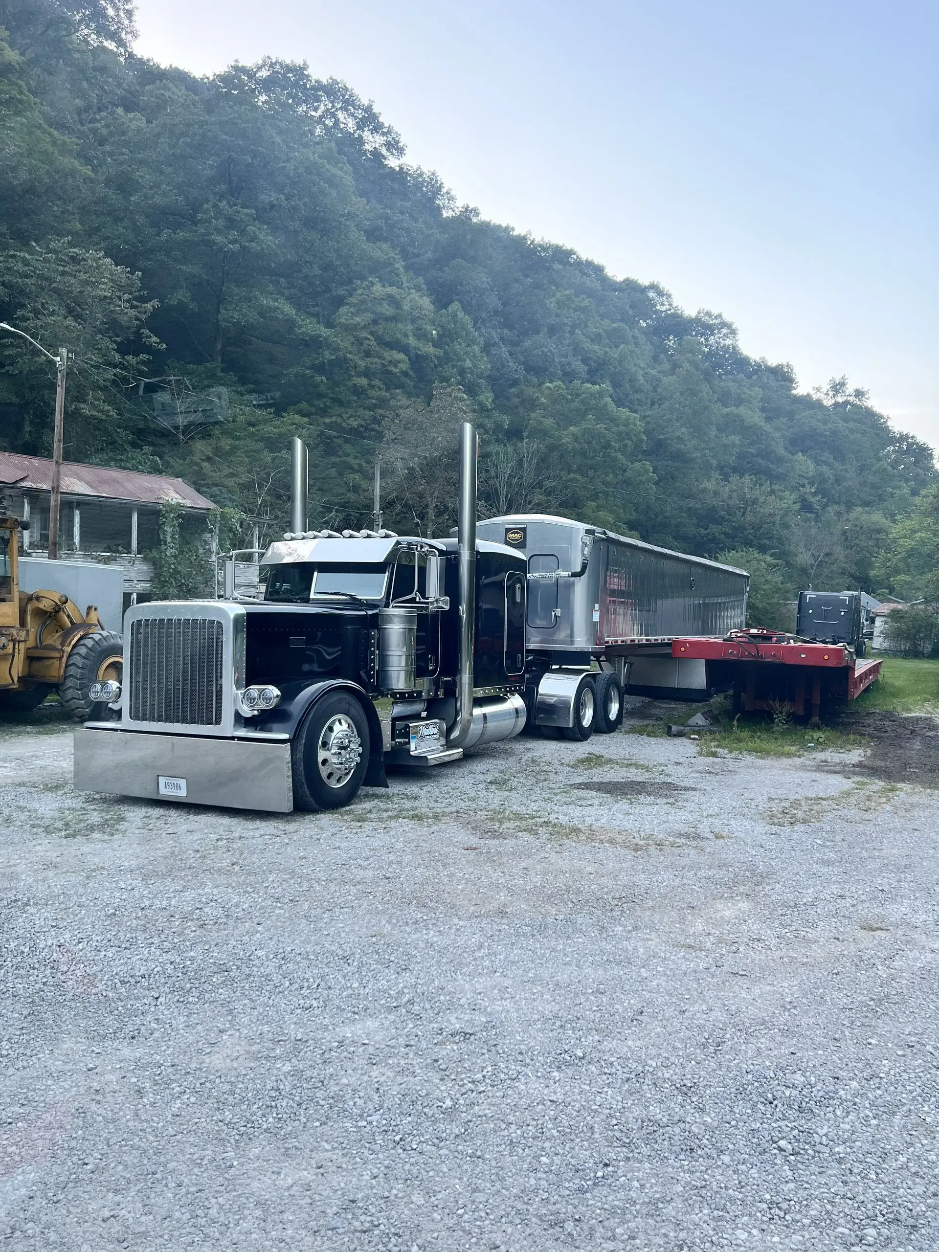 Black Mullins Trucking Peterbilt with a dump trailer and lowboy in the Jenkins, KY yard