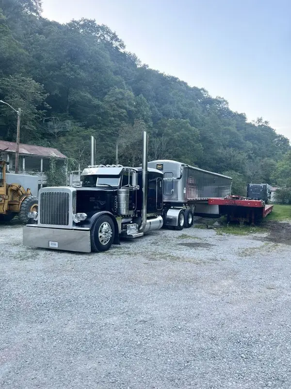 Black Mullins Trucking Peterbilt with a dump trailer and lowboy in the Jenkins, KY yard