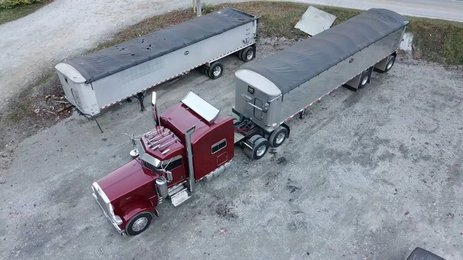 Aerial view of a maroon Mullins Trucking Peterbilt hitched to tarped aluminum grain trailers
