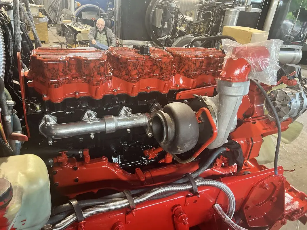 Freshly rebuilt red diesel engine on a stand in the Mullins Trucking shop