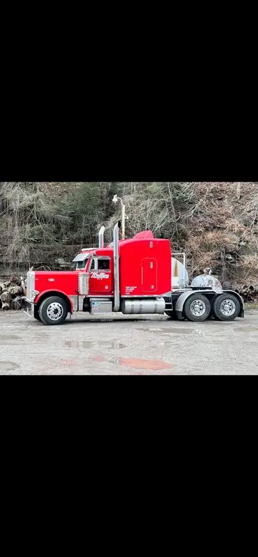 Red Mullins Trucking Peterbilt parked bobtail on a gravel lot