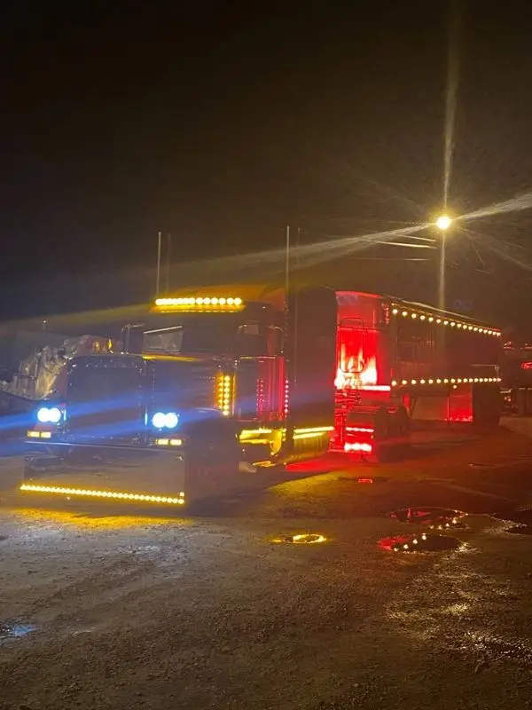 Mullins Trucking tractor and trailer running amber marker lights at night